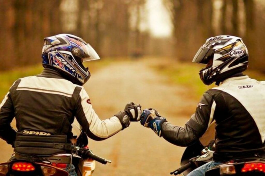 2 bikers fist pumping - group motorcycle riding