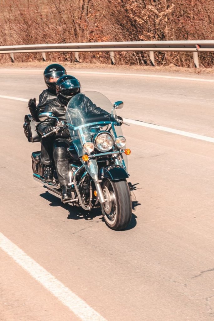 rider with waving pillion - motorcycle touring holiday
