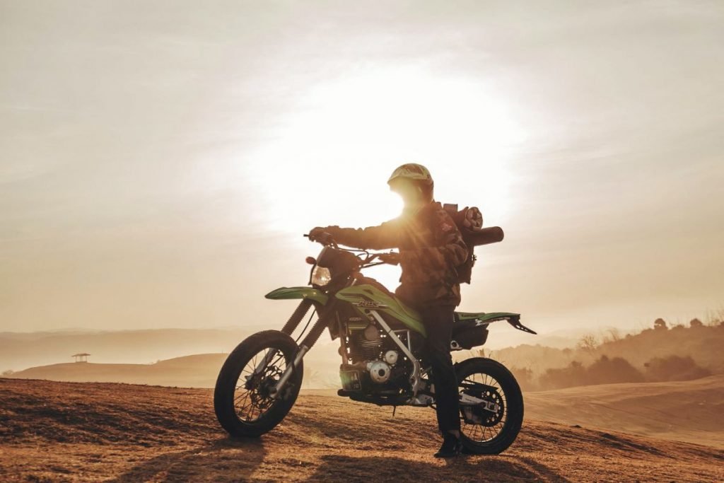 rider off-road at sunset - motorcycle touring holiday