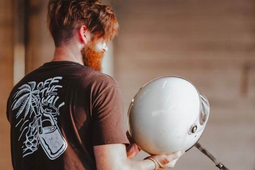 rider holding helmet - inspect motorcycle helmet