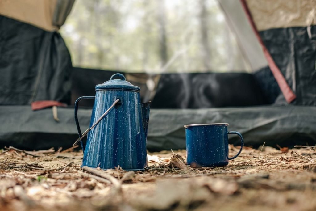 camping on a motorcycle - cup and water can